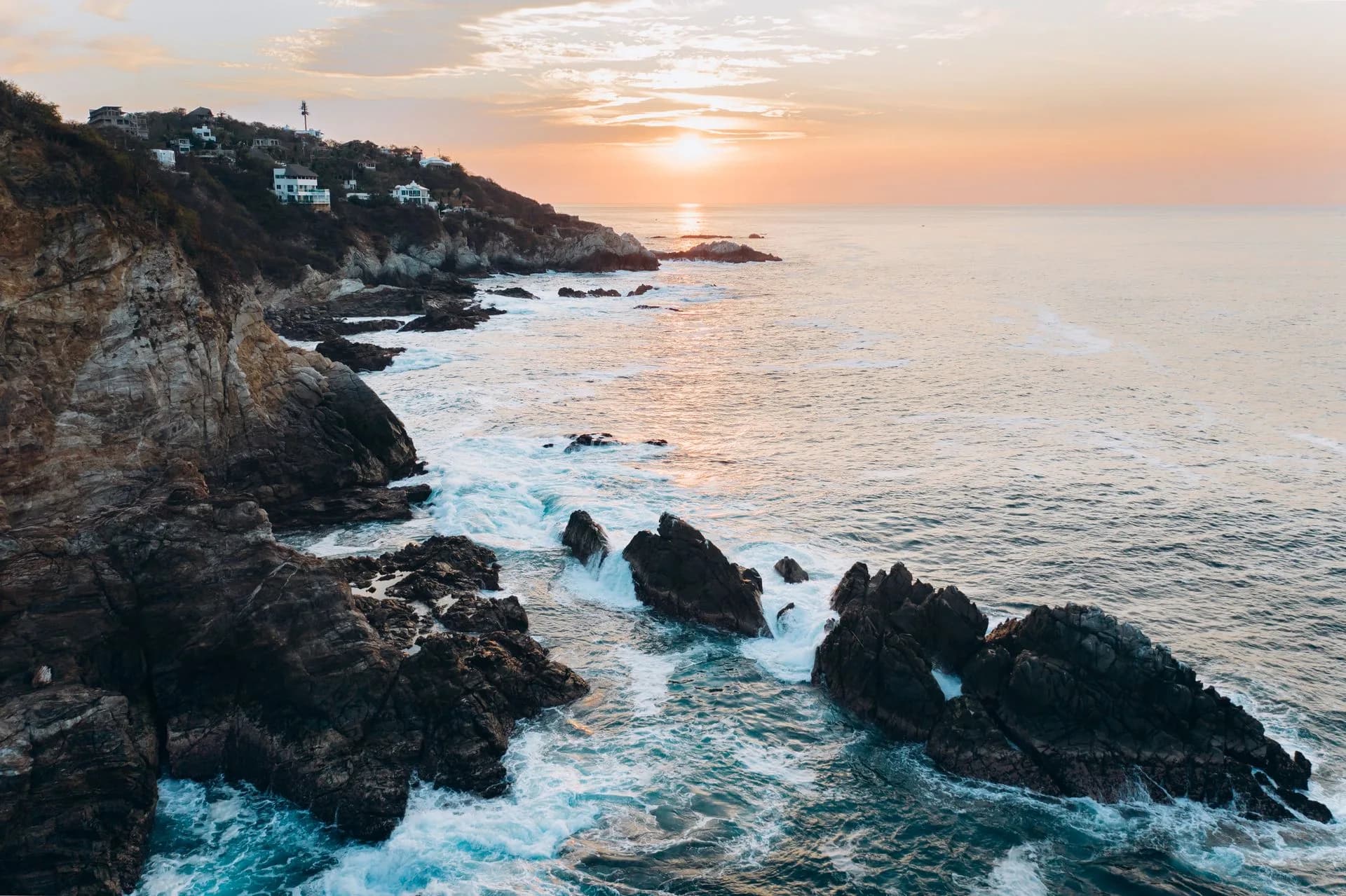 Dramatic coastal cliffs meeting the ocean at sunset along the Southern California coastline