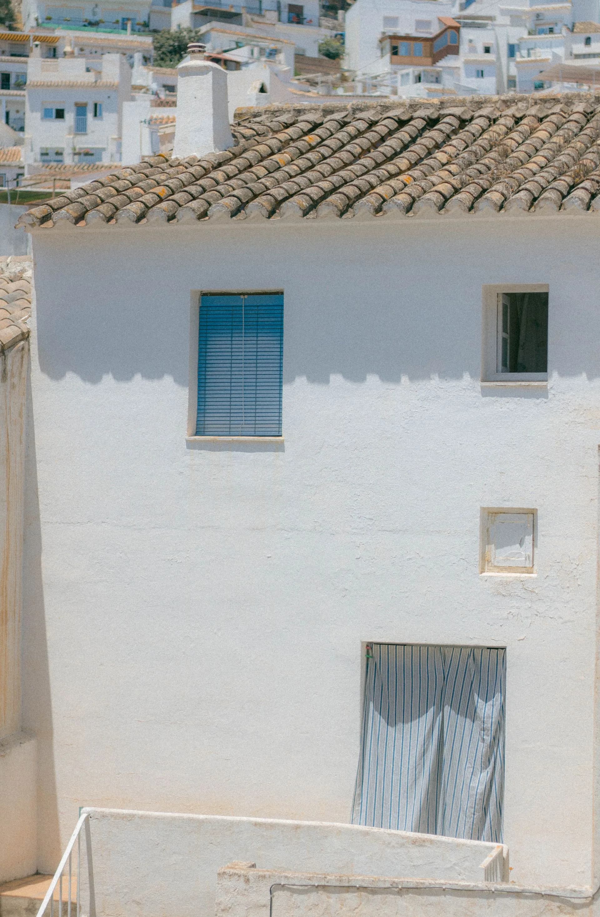 A whitewashed Mediterranean-style hillside village with terracotta roof tiles